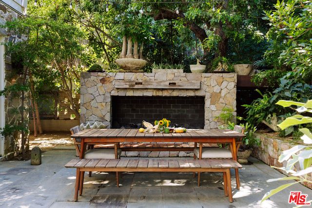 a view of a patio with a dining table and chairs with a fire pit and wooden fence