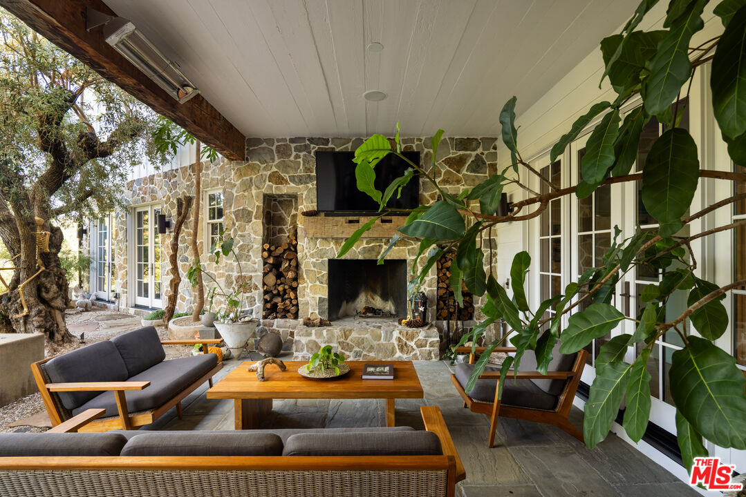 664 Elkins Road Los Angeles, CA 90049 - Photo 4 of 40 a view of a patio with couches table and chairs and potted plants