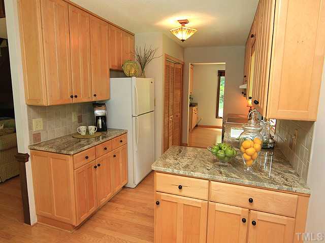 8728 Danbury Circle Raleigh, NC 27613 - Photo 10 of 25 View of the gorgeous exotic granite counter tops, ceramic tile back splash and lovely hardwood floors.