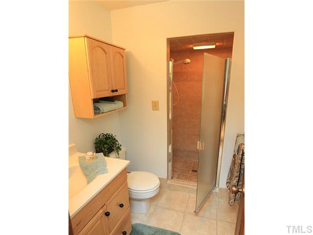 8728 Danbury Circle Raleigh, NC 27613 - Photo 16 of 25 Master Bath with ceramic tile flooring, walk in shower and maple cabinets