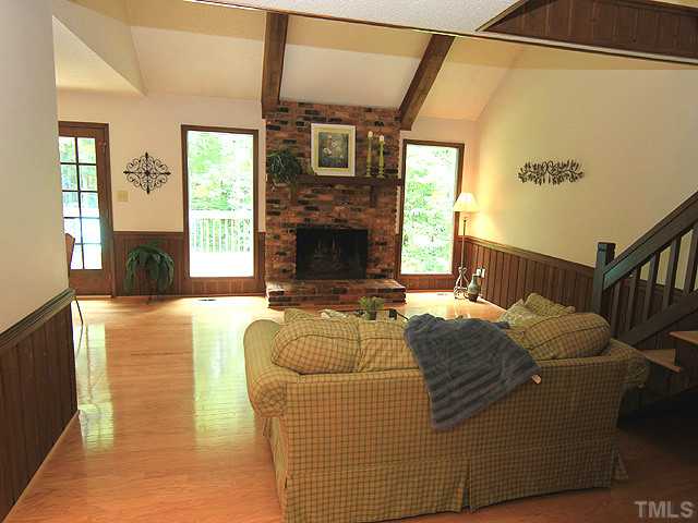 8728 Danbury Circle Raleigh, NC 27613 - Photo 4 of 25 Dramatic views of the lush back yard from the double pane windows in the Living Room. Oversized wood burning fireplace, with gorgeous heart and mantle. Cathedral ceiling and lovely hardwoods.