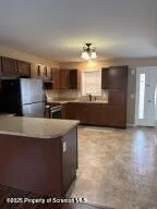 a kitchen with kitchen island granite countertop a sink a stove and refrigerator