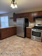 1343 Church Avenue Scranton, PA 18508 - Photo 4 of 22 a kitchen with granite countertop a stove a sink and a refrigerator