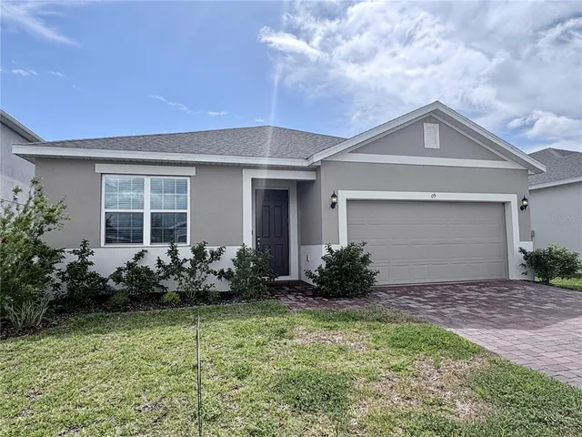 a front view of house with yard and yellow lighting