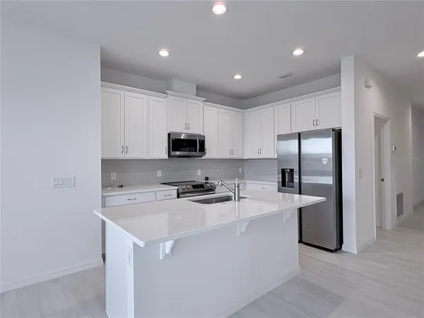 a kitchen with stainless steel appliances a refrigerator sink and microwave