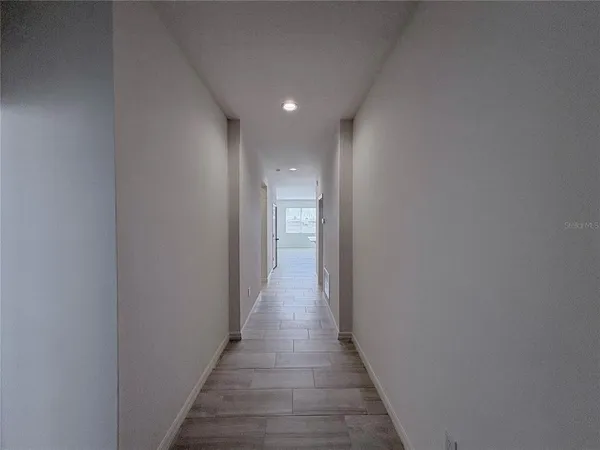 a view of a hallway with wooden floor