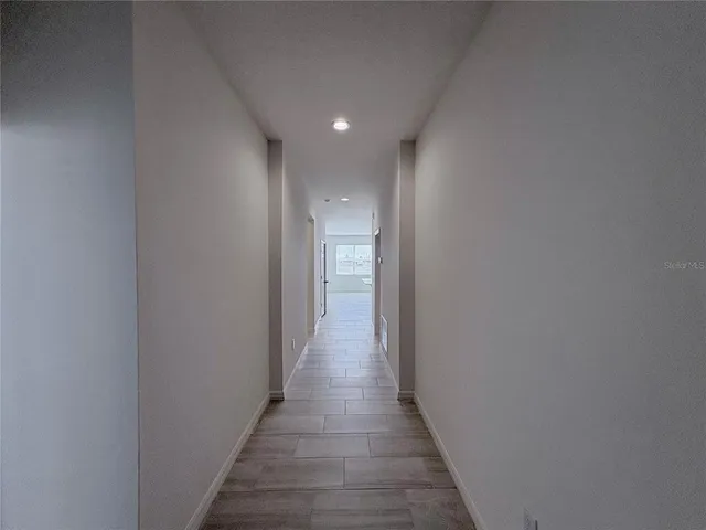a view of a hallway with wooden floor