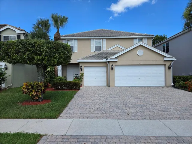 a front view of a house with a garden and plants