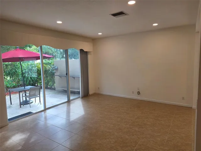 an empty room with a ceiling fan and window