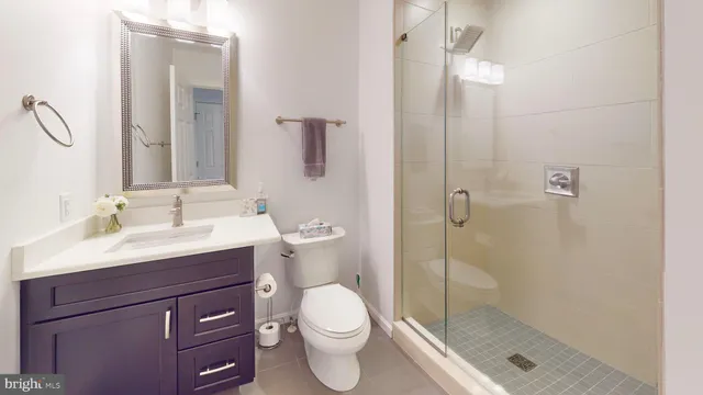 a bathroom with a shower sink vanity mirror and toilet