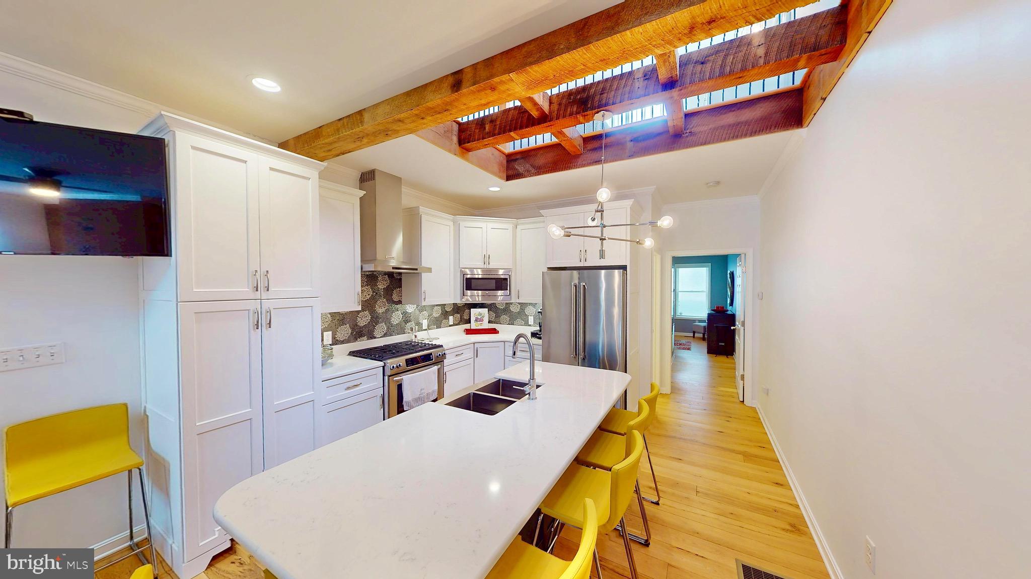 306 South Exeter Street Baltimore, MD 21202 - Photo 3 of 35 a kitchen with stainless steel appliances granite countertop a sink a stove and a refrigerator