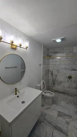 a bathroom with a sink a toilet and mirror