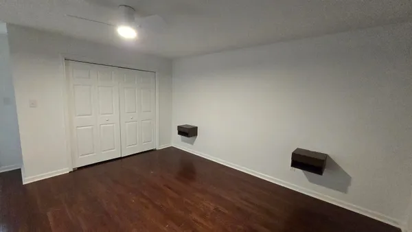 a view of an empty room with wooden floor