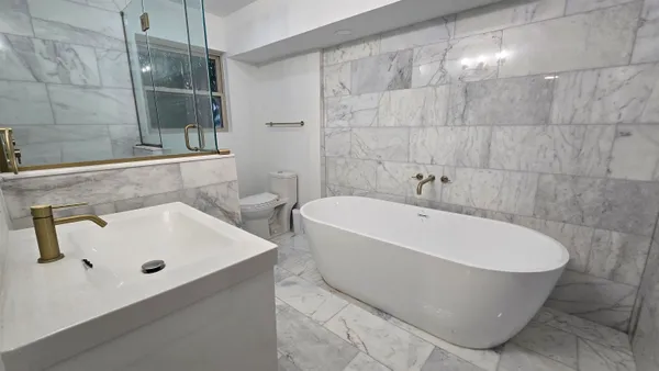 a white bath tub sitting in a bathroom and sink