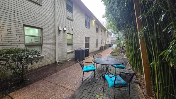 a view of a chairs and table in backyard of the house