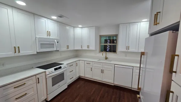 a kitchen with white cabinets and white appliances