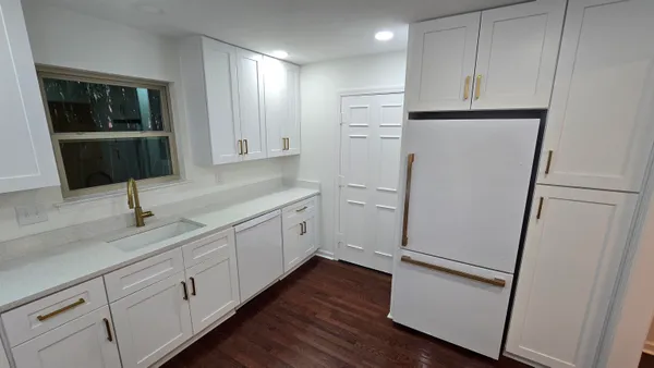 a kitchen with white cabinets and white appliances