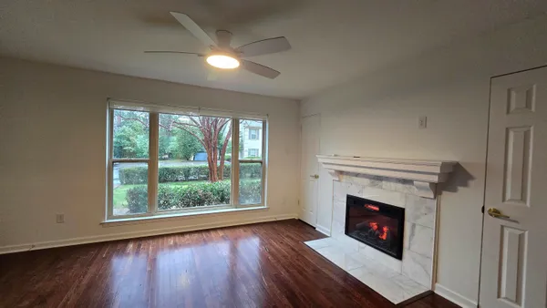 a living room with a fireplace and a floor to ceiling window