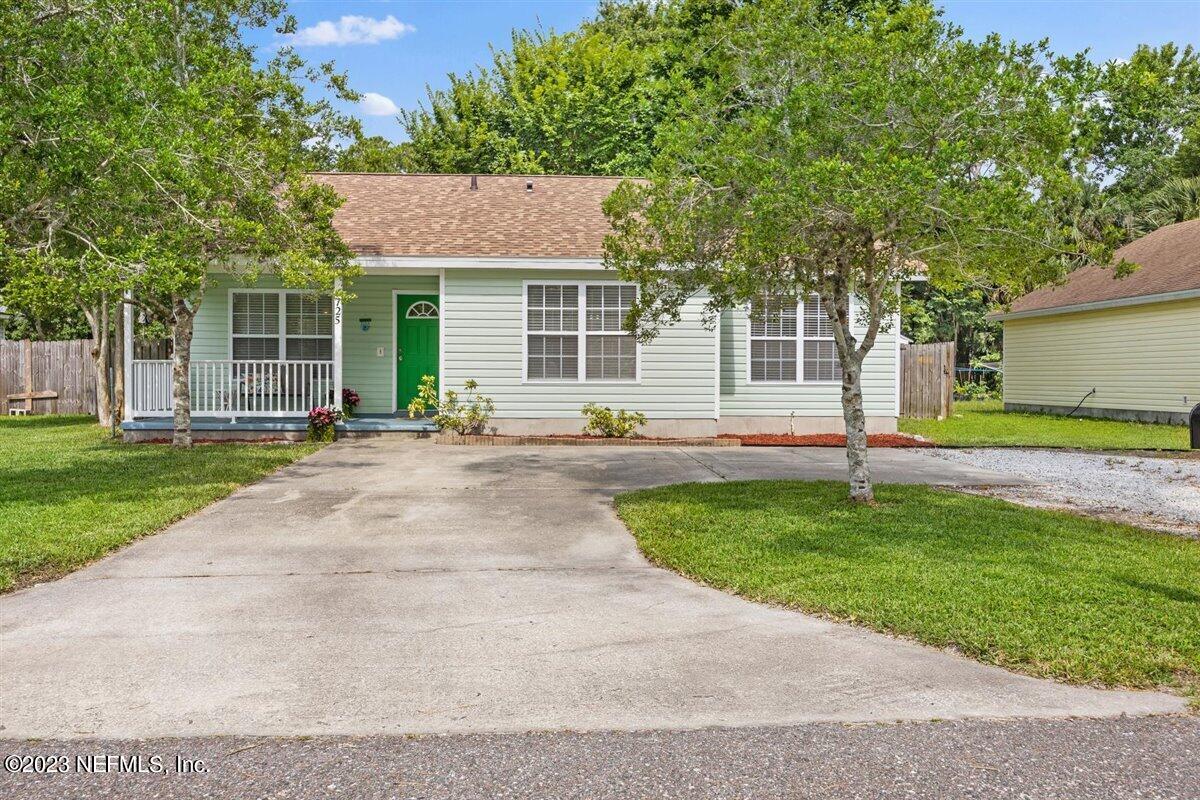 a view of a house with a yard and tree s