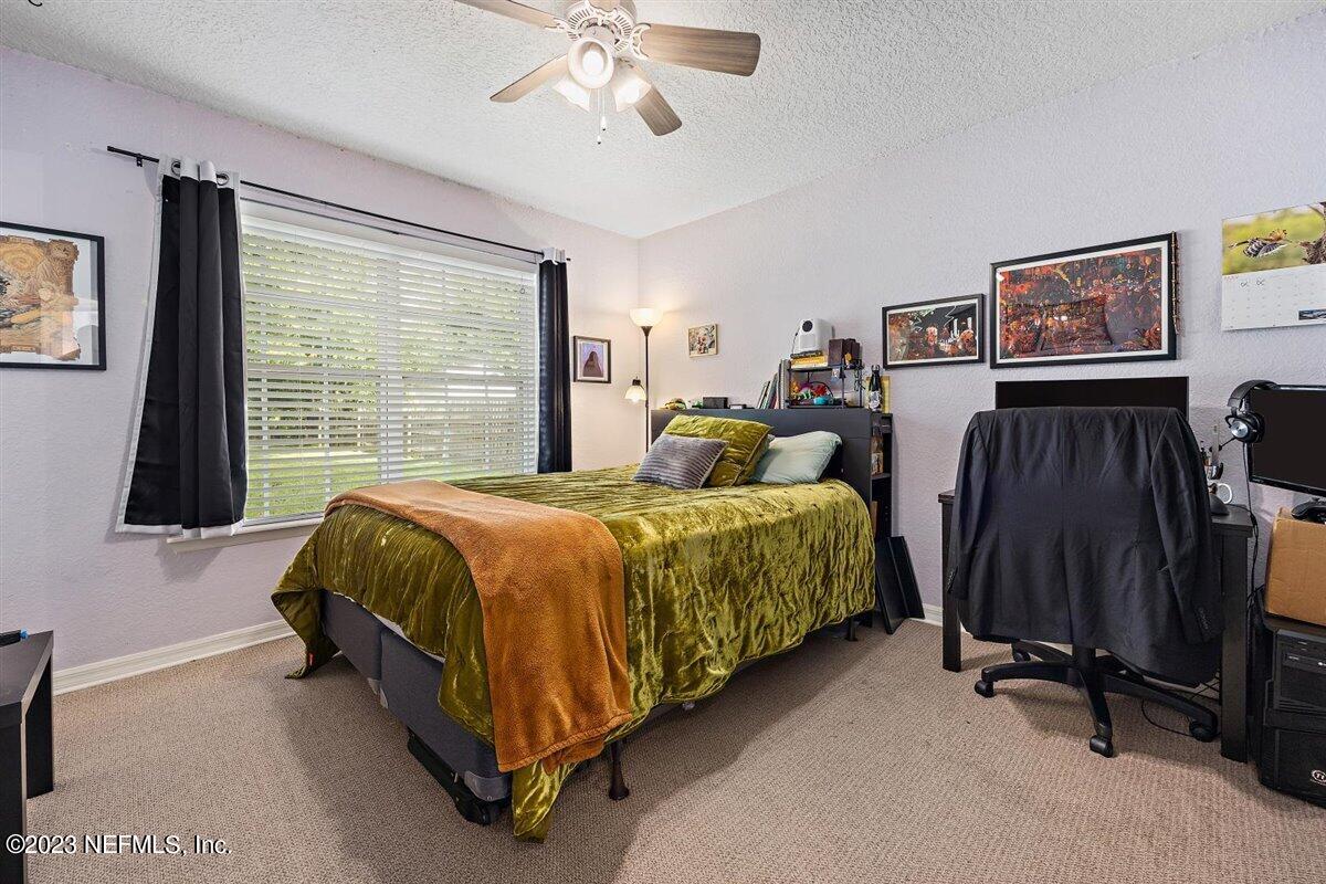725 Alexander Street St. Augustine, FL 32084 - Photo 6 of 13 a spacious bedroom with a bed and a flat tv screen on the dresser