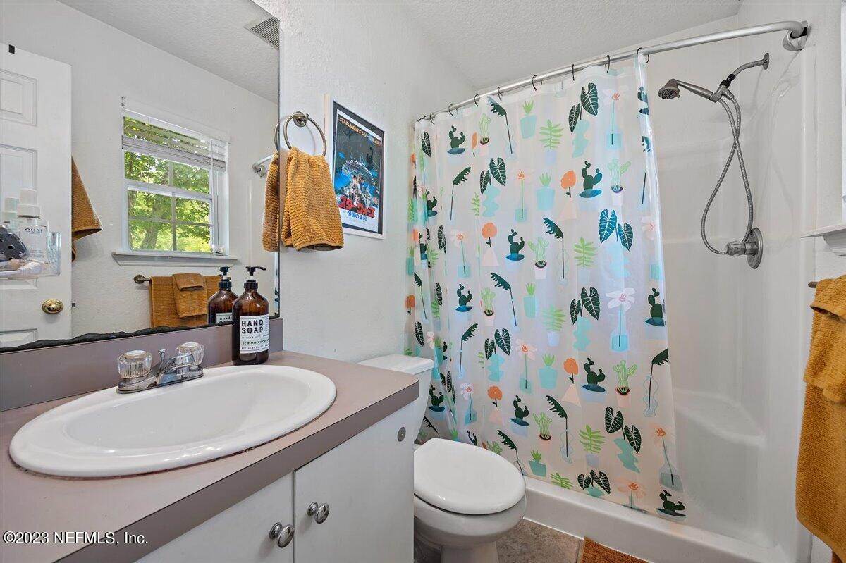 725 Alexander Street St. Augustine, FL 32084 - Photo 7 of 13 a bathroom with a sink a toilet and a mirror