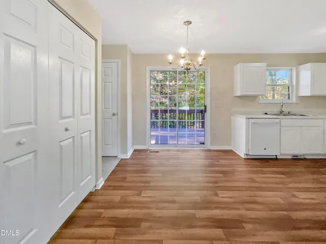 a view of a kitchen with granite countertop cabinets and chandelier