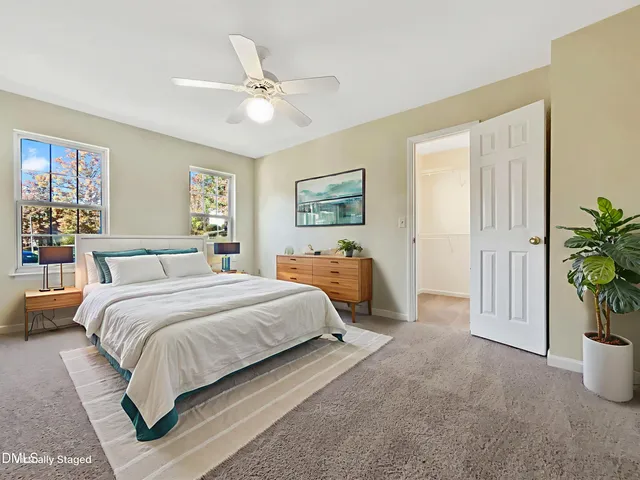 a spacious bedroom with a bed a couch and potted plant