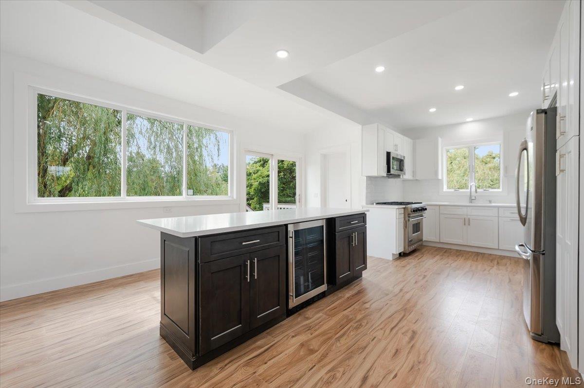 56 Oak Beach Road Babylon, NY 11702 - Photo 12 of 30 Newly remodeled kitchen shines with a oversized center island with quartz countertops and stainless steel appliances.