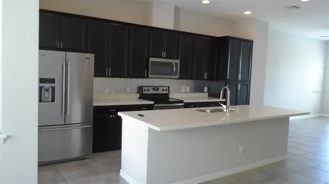 a kitchen with appliances a sink and a refrigerator