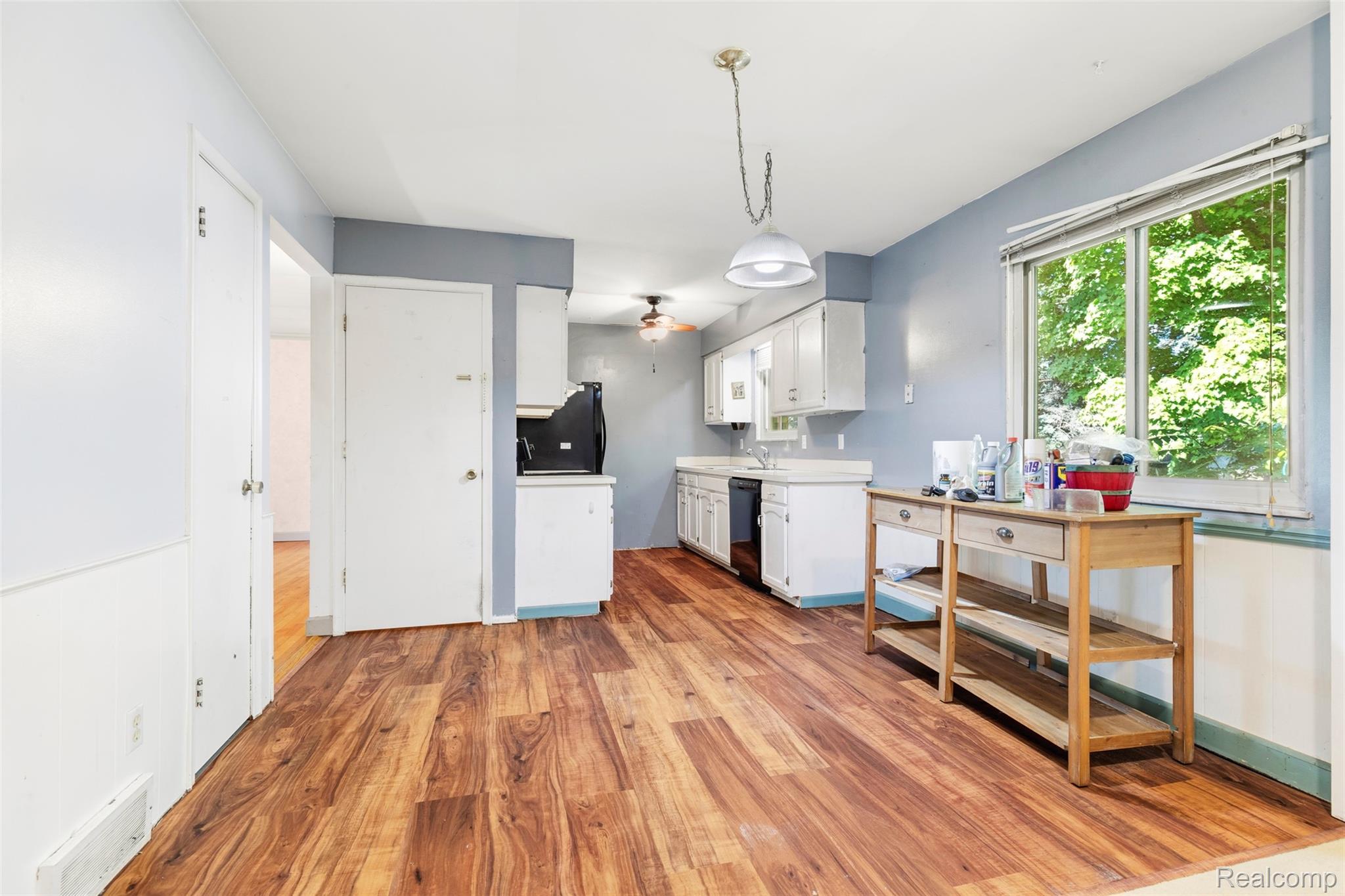 309 Windy Bluff Street Flushing, MI 48433 - Photo 5 of 32 Kitchen area featuring wood-finish flooring, white cabinetry, and a large window