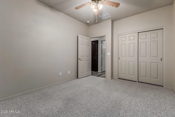 an empty room with chandelier fan