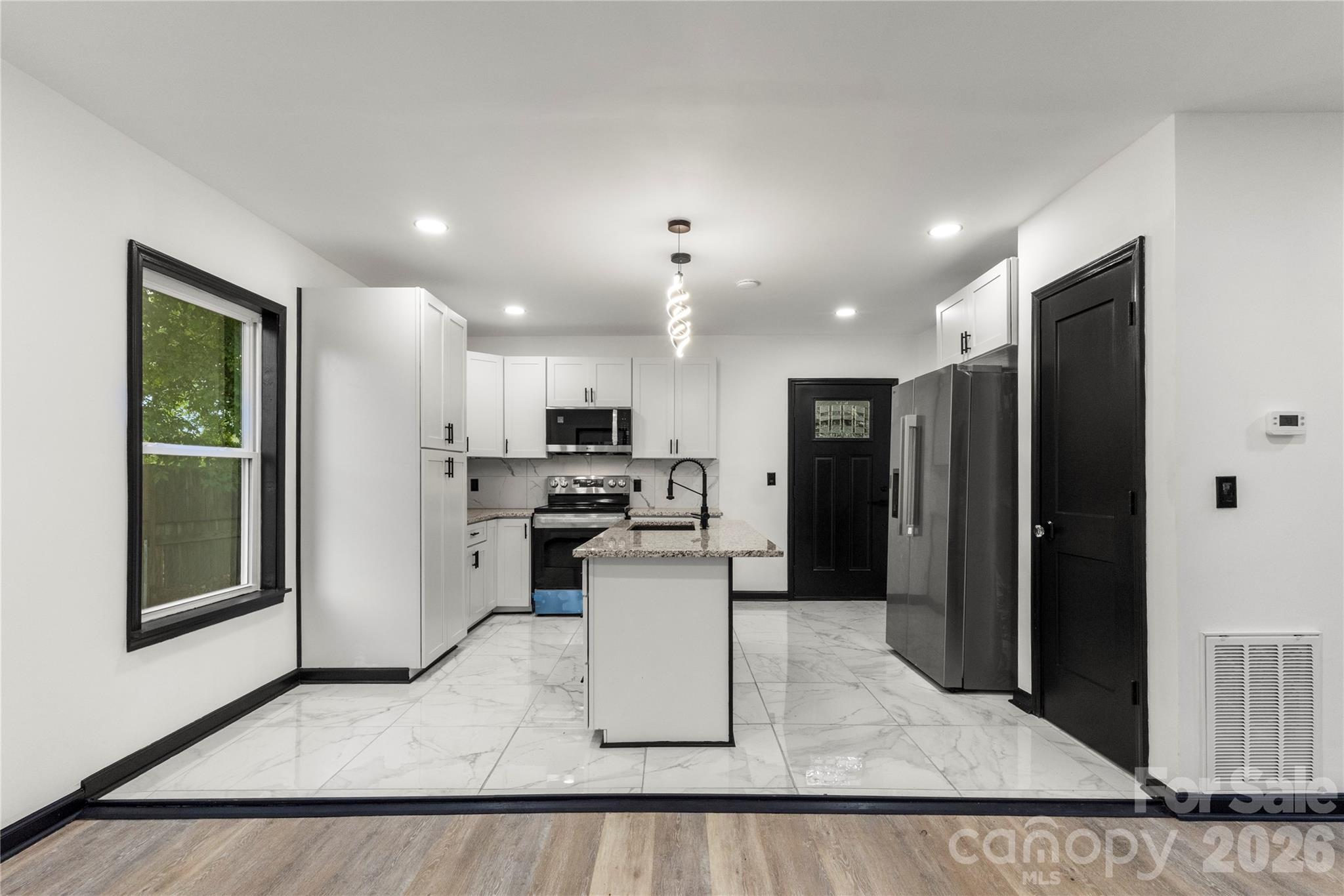 110 Courtland Street Chester, SC 29706 - Photo 6 of 22 a kitchen with stainless steel appliances kitchen island granite countertop a refrigerator and a sink