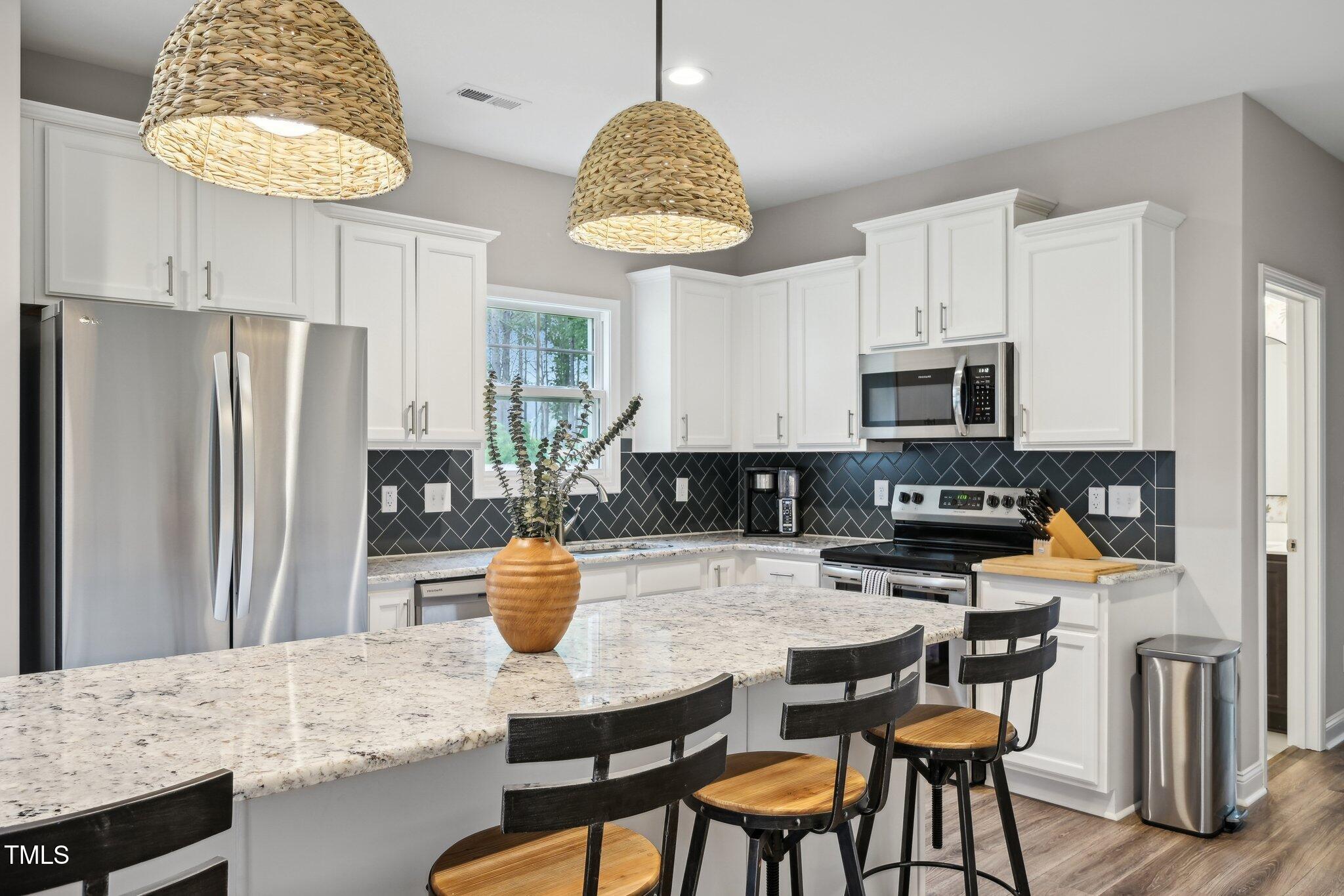 195 Solomon Drive Cameron, NC 28326 - Photo 14 of 46 a kitchen with stainless steel appliances granite countertop a table chairs and a refrigerator