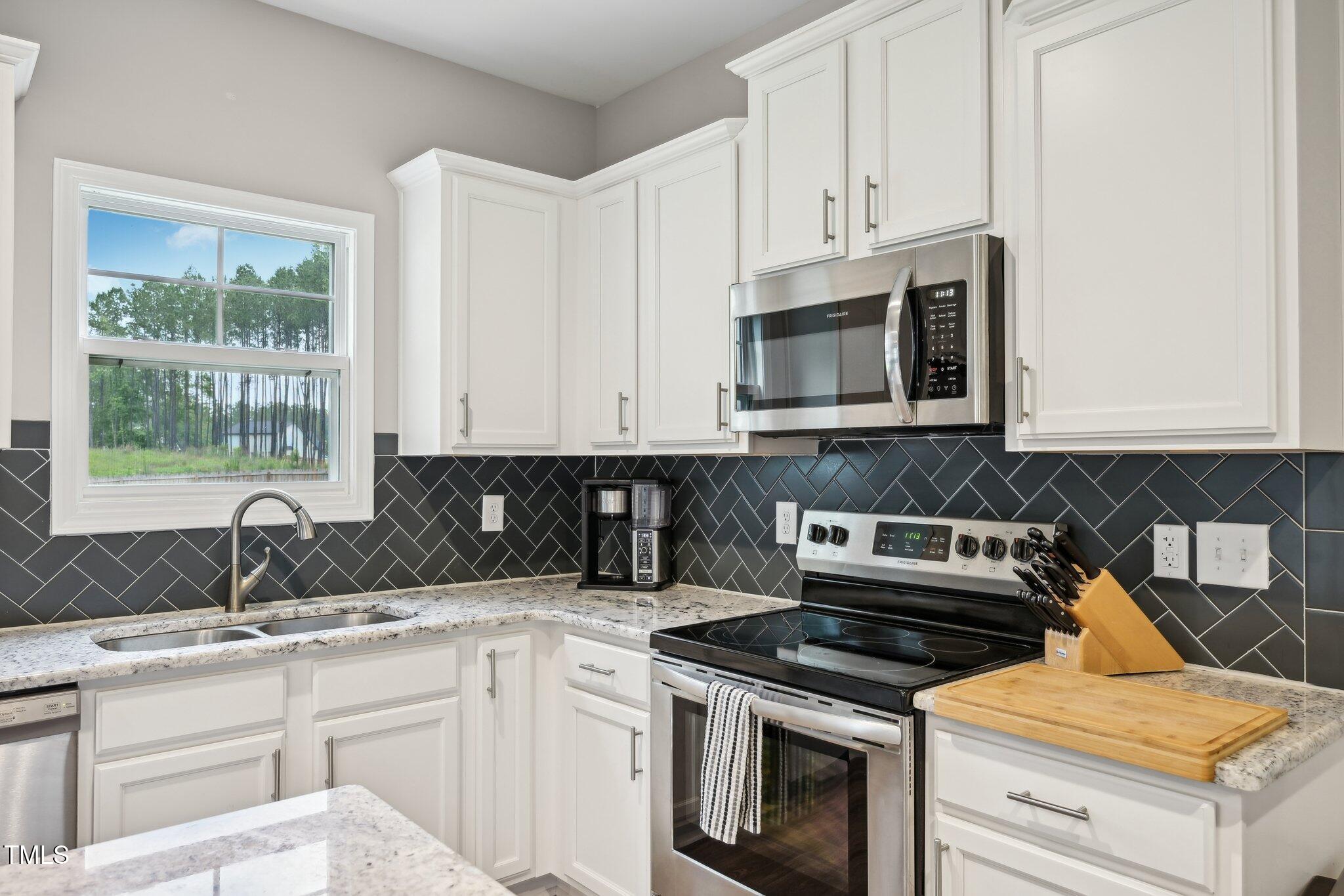 195 Solomon Drive Cameron, NC 28326 - Photo 15 of 46 a kitchen with granite countertop white cabinets and white appliances