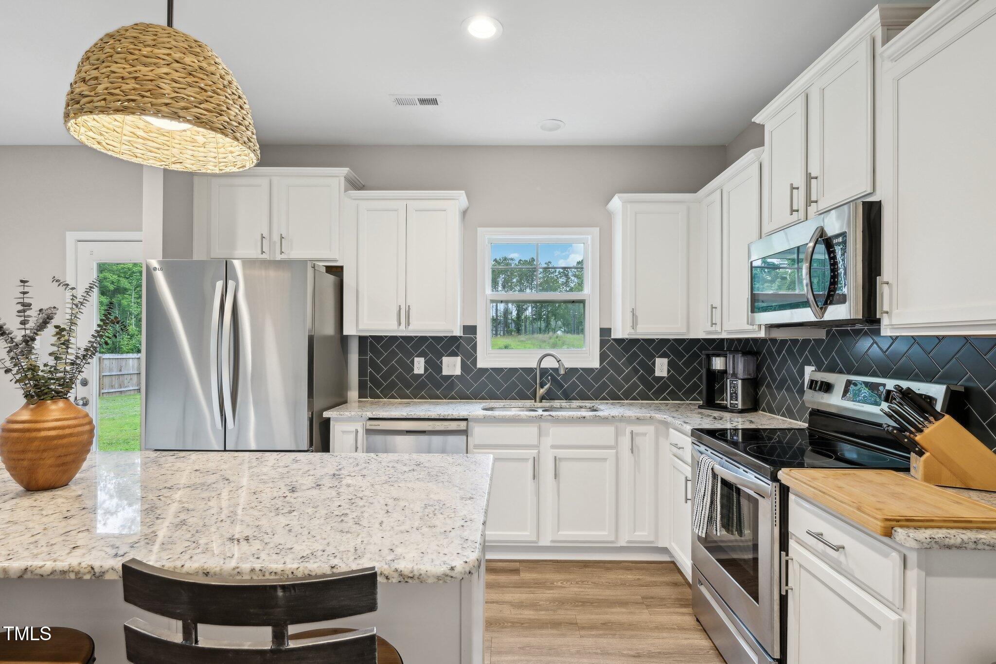 195 Solomon Drive Cameron, NC 28326 - Photo 16 of 46 a kitchen with stainless steel appliances granite countertop a sink a stove a refrigerator cabinets and chairs