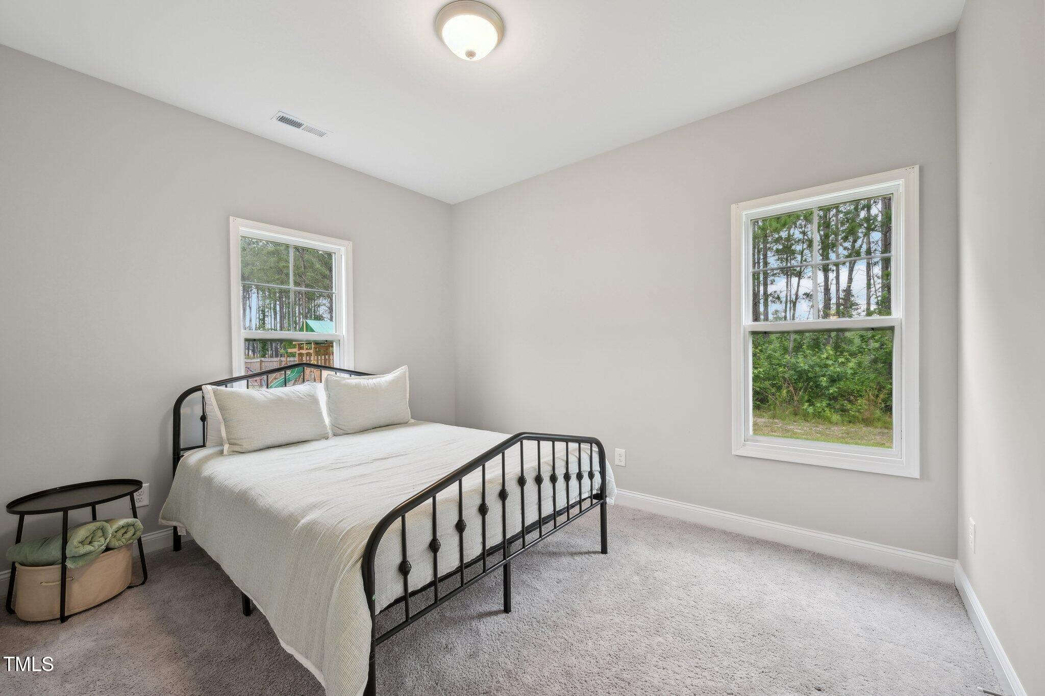 195 Solomon Drive Cameron, NC 28326 - Photo 22 of 46 a bedroom with a bed lamp and a window