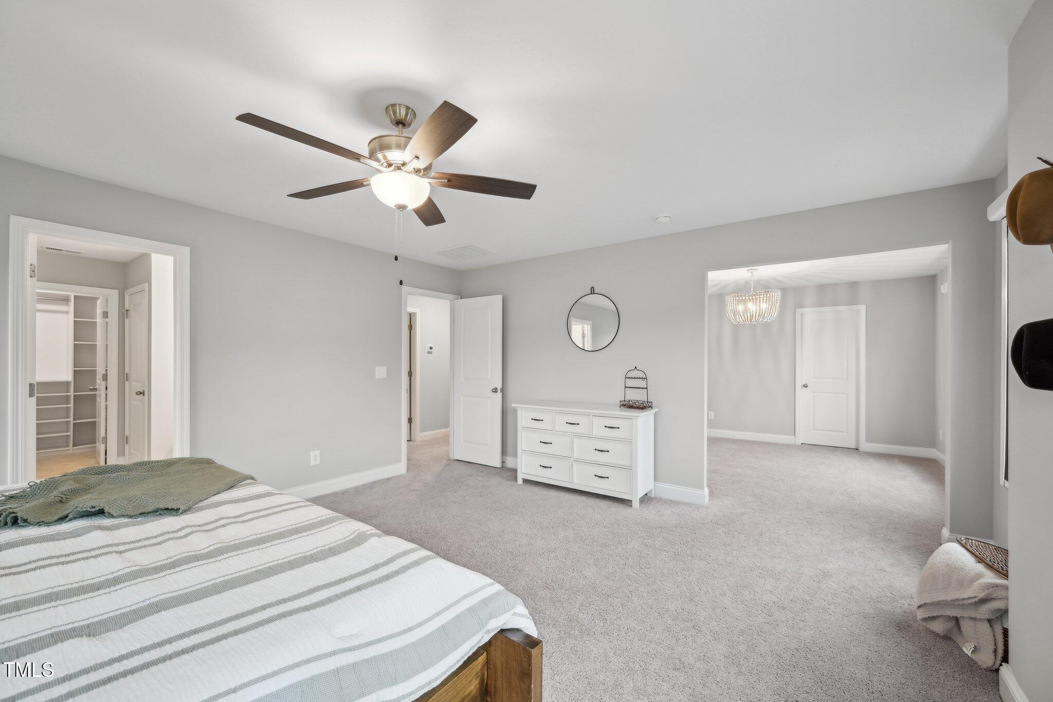 195 Solomon Drive Cameron, NC 28326 - Photo 26 of 46 a bedroom with a bed and a chandelier