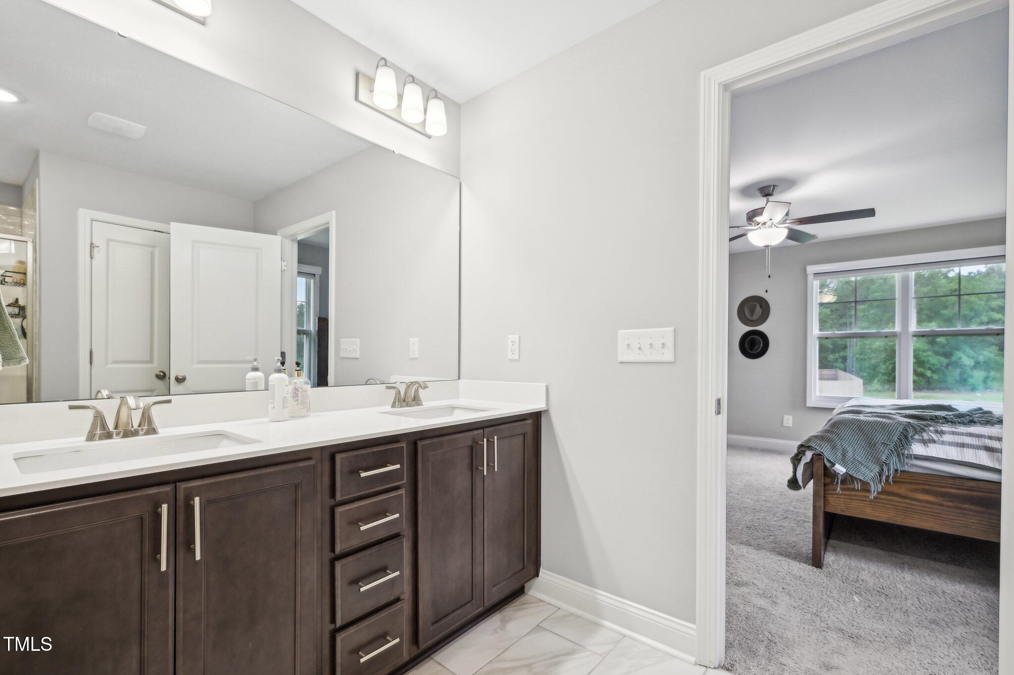 195 Solomon Drive Cameron, NC 28326 - Photo 32 of 46 a en suite bathroom with a double vanity sink a mirror and a bathtub