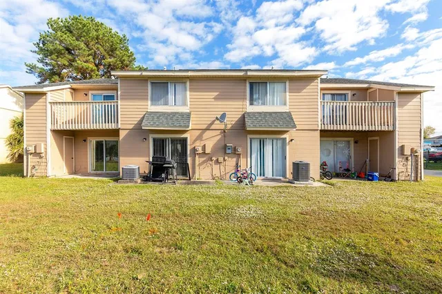 a view of a white house with a large windows and a yard