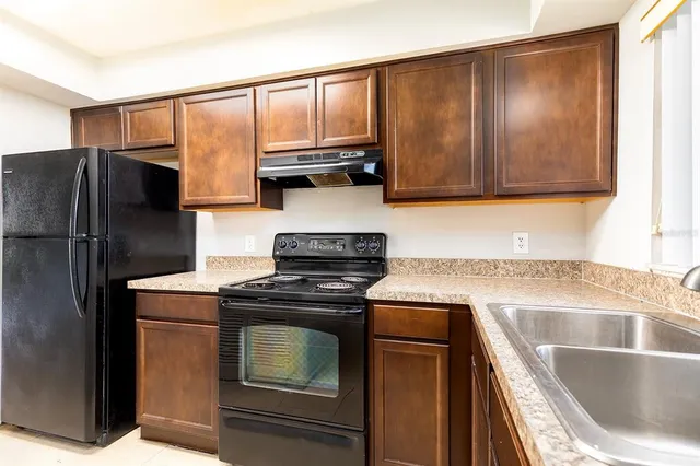 a kitchen with a stove a fridge and a sink