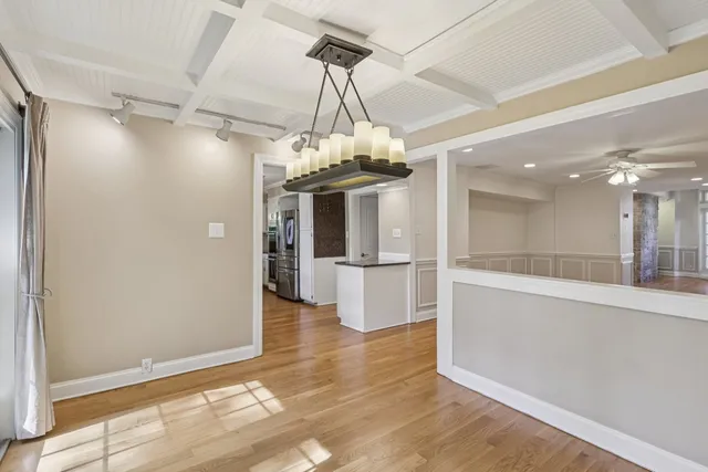 a view of a room with a chandelier and wooden floor