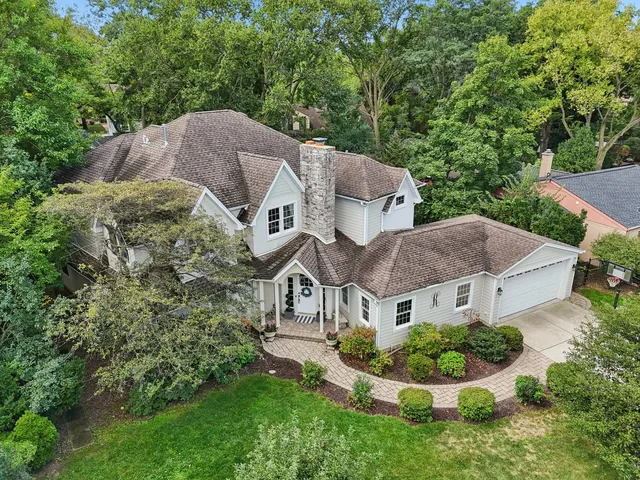 a aerial view of a house with a yard and large trees