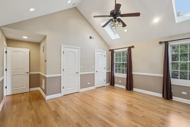 an empty room with a window and a ceiling fan