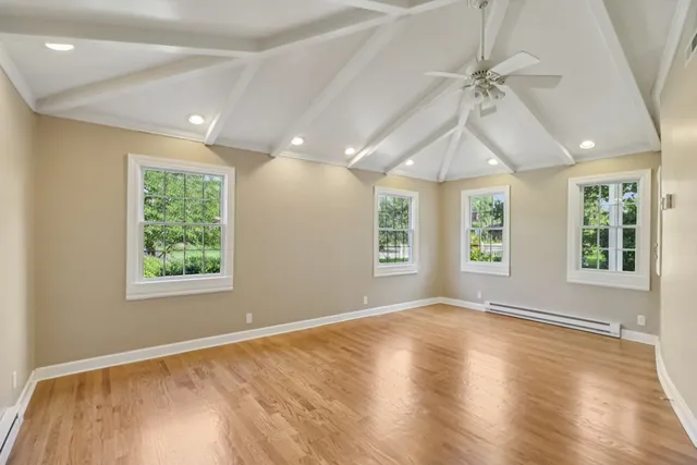 a view of a hallway with wooden floor and a kitchen