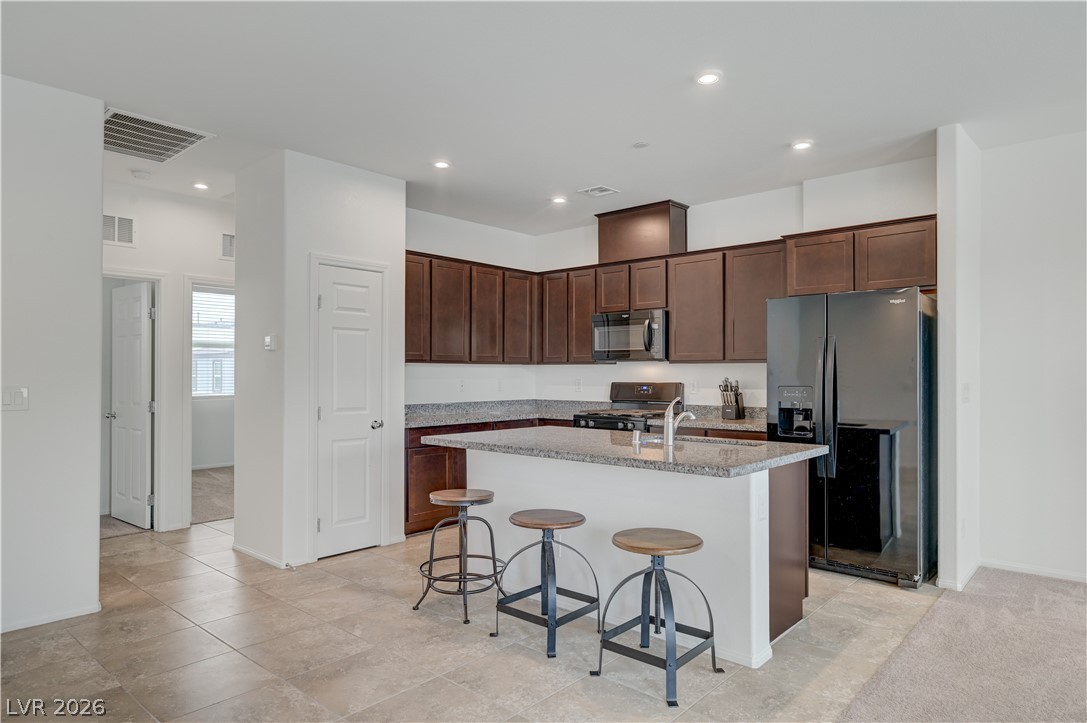 1287 Raritan Place Henderson, NV 89002 - Photo 12 of 21 A well-appointed kitchen features dark wood cabinets and a spacious granite island perfect for entertaining.