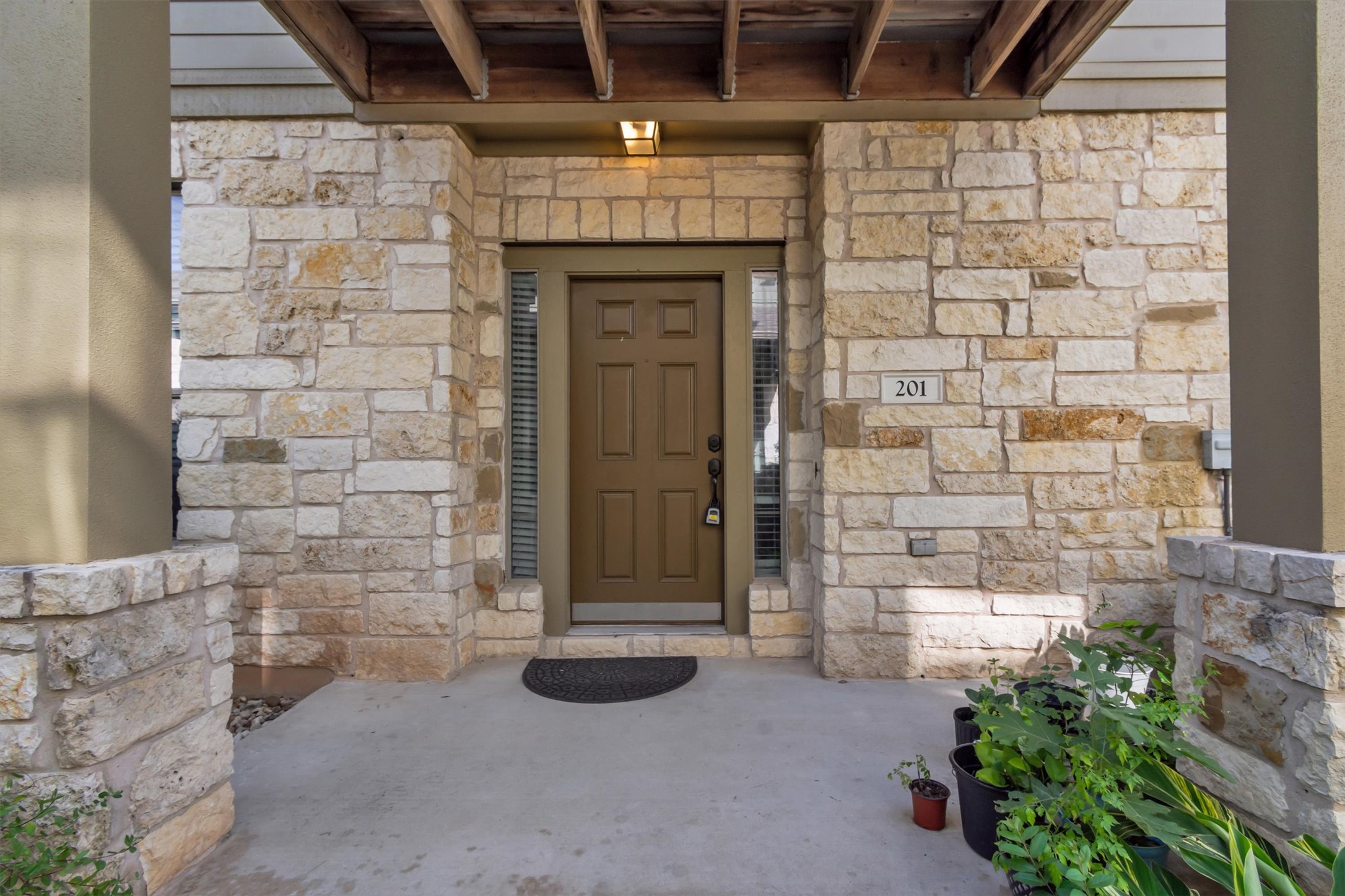 14815 Avery Ranch Boulevard, Unit 2A Austin, TX 78717 - Photo 25 of 27 A welcoming entry framed by robust stone construction, topped with a sturdy pergola, offers appealing curb appeal.