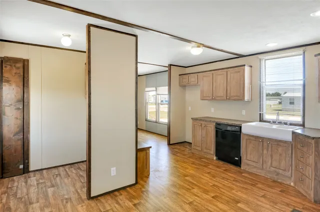 a kitchen with a sink cabinets stainless steel appliances and a window