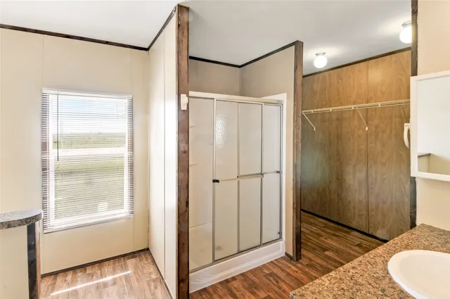 an empty room with windows and ceiling fan