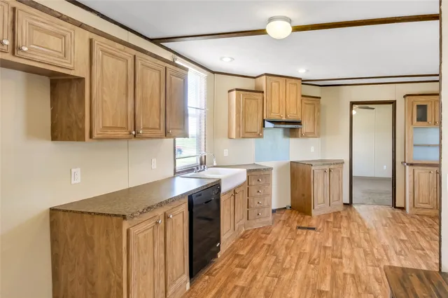 a kitchen with stainless steel appliances granite countertop a refrigerator and a stove top oven with wooden floor