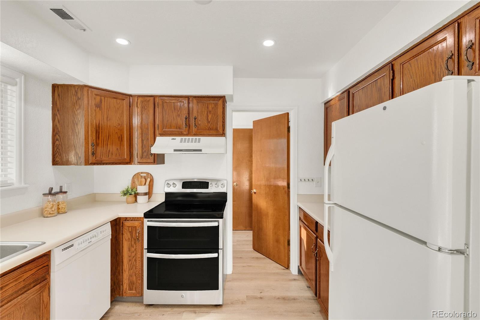 5210 Estes Circle Arvada, CO 80002 - Photo 13 of 29 a kitchen with a refrigerator a stove a sink dishwasher and a stove with wooden floor